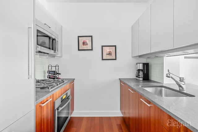 kitchen with sink, white cabinetry, stainless steel appliances, and tasteful backsplash