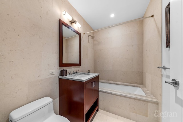 full bathroom featuring toilet, tiled shower / bath, tile walls, and vanity