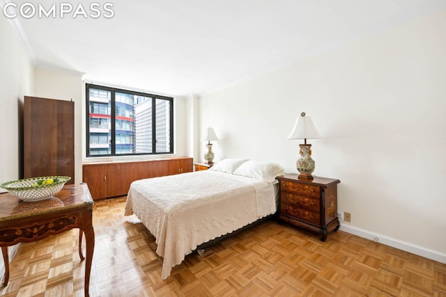 bedroom featuring ornamental molding and light parquet flooring