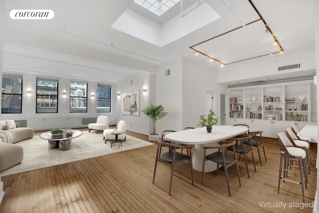 dining room featuring light wood finished floors, rail lighting, and visible vents