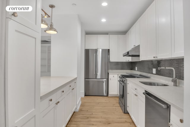 kitchen with under cabinet range hood, white cabinetry, stainless steel appliances, and light countertops