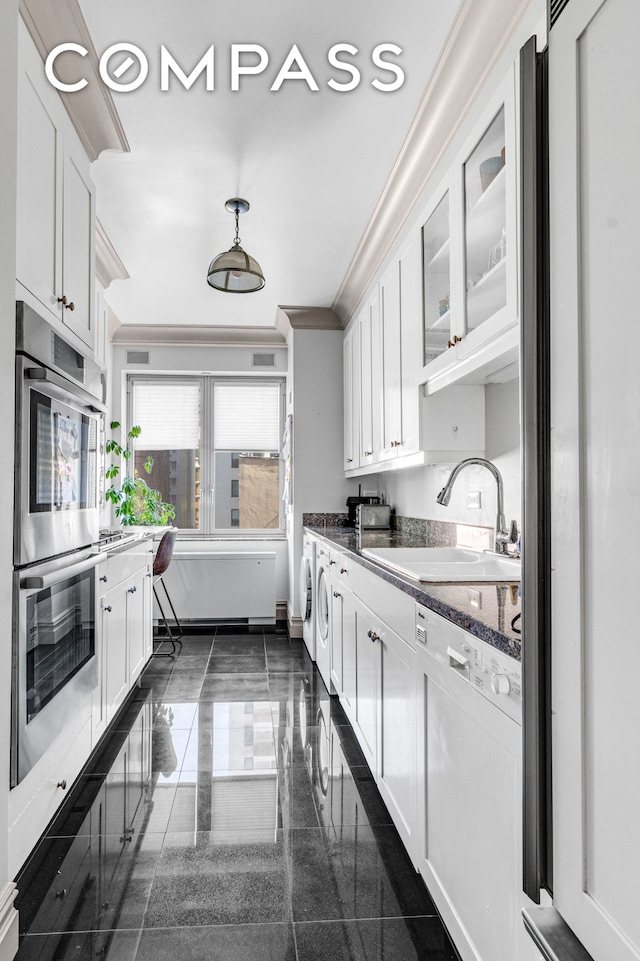 kitchen with granite finish floor, double oven, white cabinets, white dishwasher, and a sink