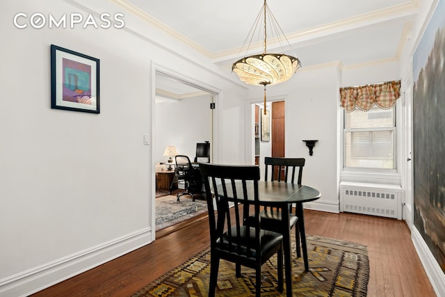 dining area with ornamental molding, radiator, baseboards, a chandelier, and dark wood finished floors