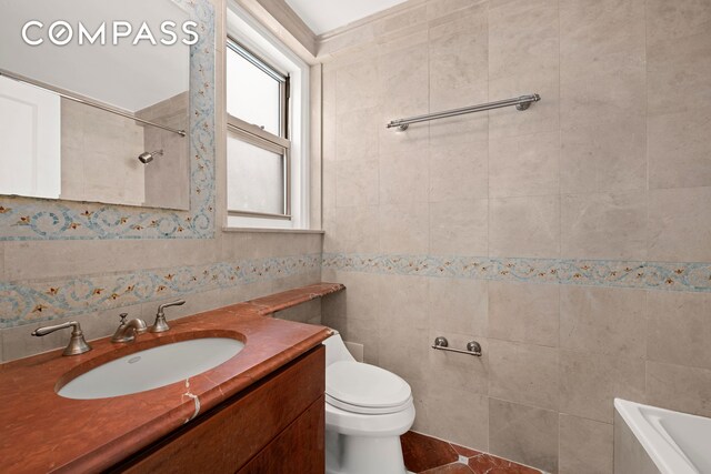 full bath with vanity, a shower, a washtub, toilet, and tile walls