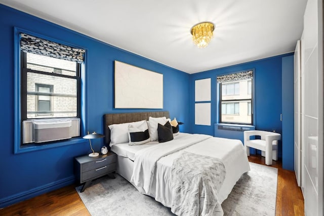 bedroom with dark wood-type flooring and radiator heating unit