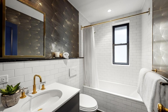 full bathroom featuring toilet, vanity, tile walls, and shower / tub combo with curtain