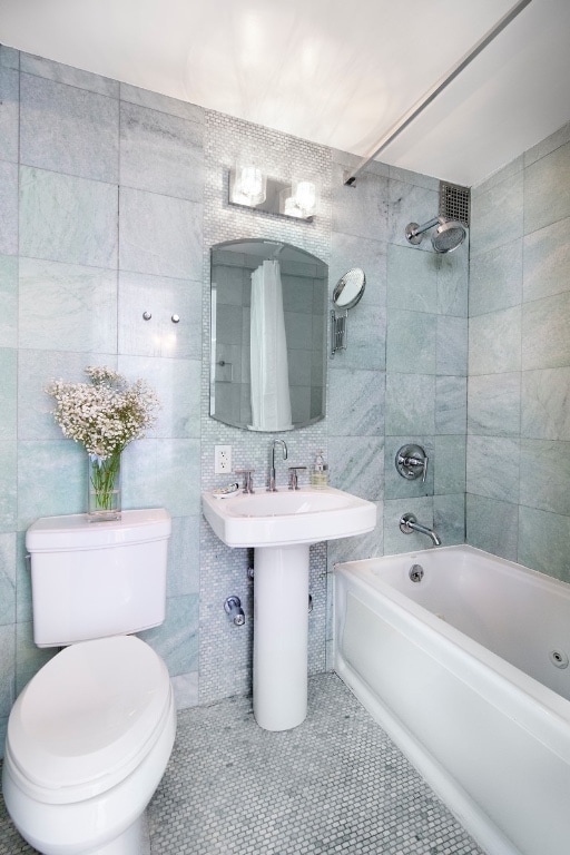 full bathroom with toilet, sink, tile walls, shower / bath combination with curtain, and tile patterned flooring