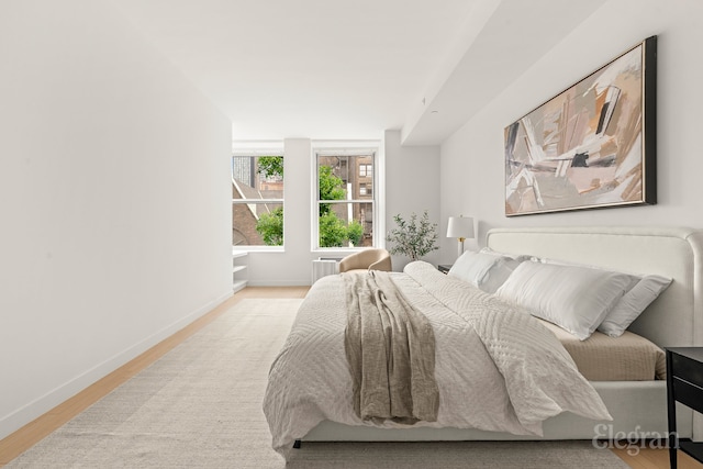 bedroom with baseboards and wood finished floors