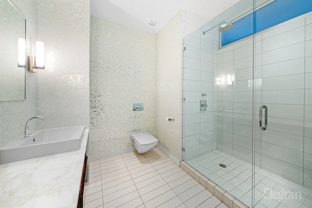 full bathroom featuring vanity, a stall shower, tile patterned flooring, tile walls, and toilet