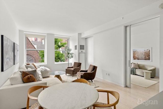 living area featuring baseboards and light wood-style floors