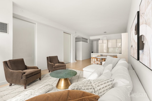 living area with visible vents and light wood-style flooring