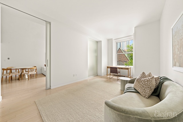 sitting room featuring baseboards and light wood finished floors