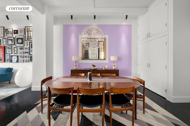 dining area with beam ceiling, wood-type flooring, and a chandelier