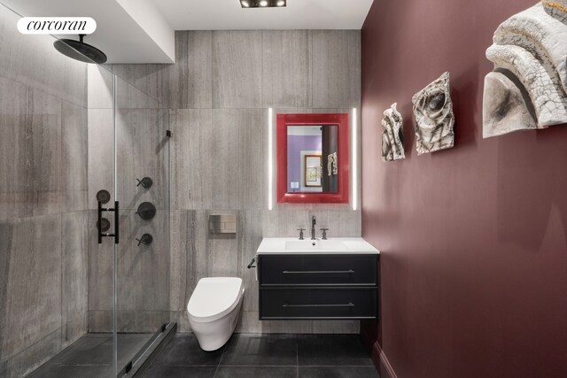 bathroom with tile patterned flooring, vanity, toilet, tile walls, and a stall shower