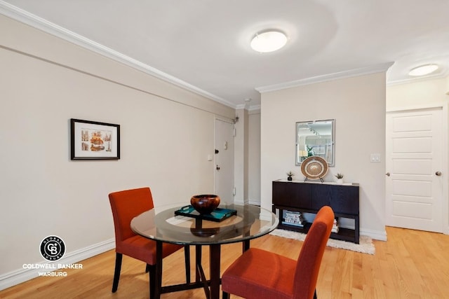 dining area featuring crown molding and light hardwood / wood-style flooring