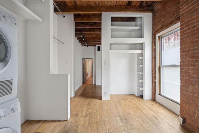 interior space featuring stacked washer and dryer, wood ceiling, light hardwood / wood-style flooring, built in features, and beamed ceiling