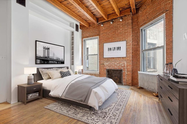 bedroom featuring multiple windows, radiator, wooden ceiling, and light hardwood / wood-style floors