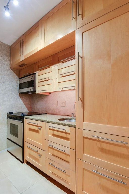 kitchen featuring light brown cabinetry, sink, appliances with stainless steel finishes, and light tile patterned floors