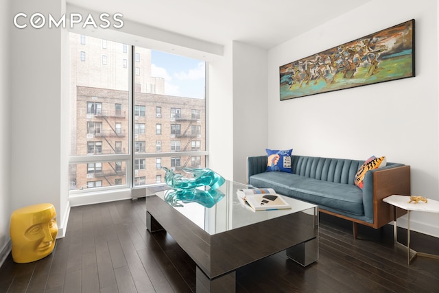 living room with dark wood-type flooring and baseboards