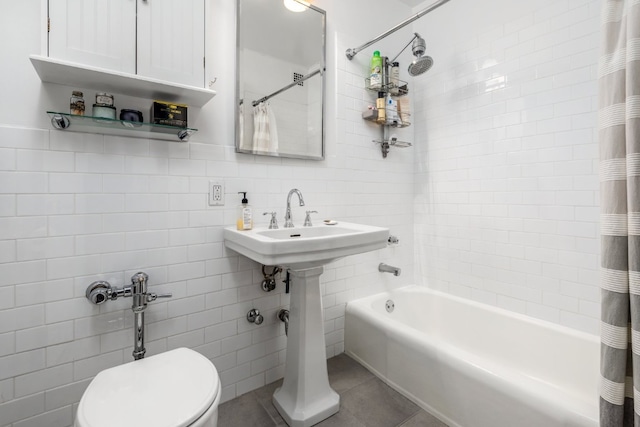 bathroom featuring tile walls, backsplash, toilet, shower / bathtub combination with curtain, and tile patterned floors