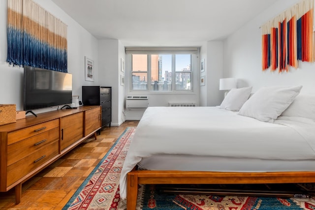 bedroom with radiator heating unit and a wall mounted AC