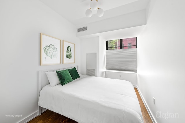 bedroom with dark hardwood / wood-style flooring