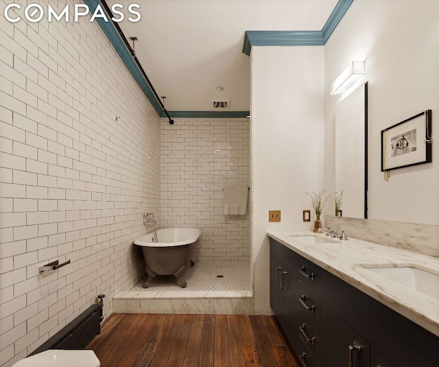 bathroom with separate shower and tub, tile walls, wood-type flooring, ornamental molding, and vanity