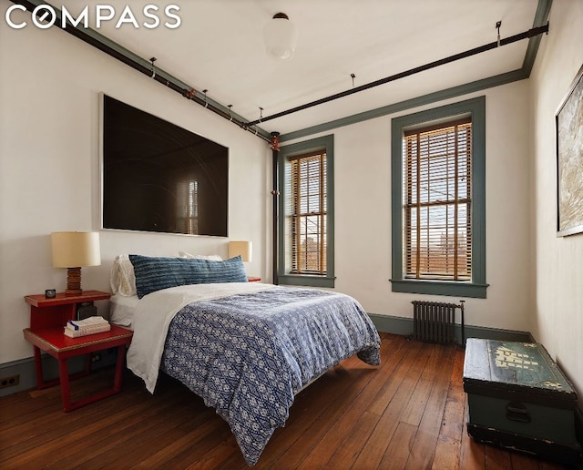 bedroom with dark wood-type flooring, radiator, and ornamental molding