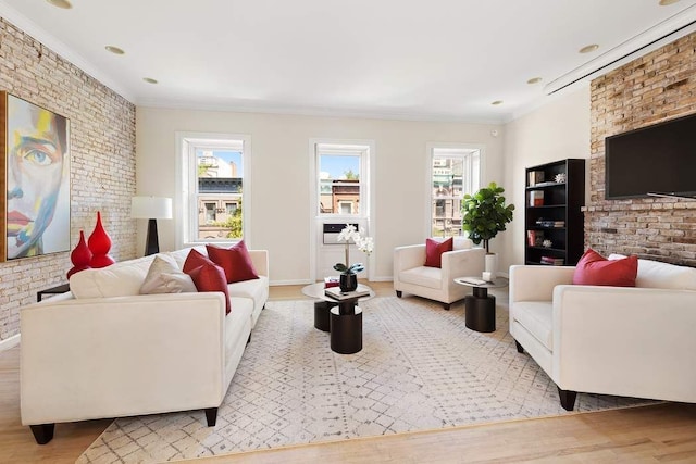 living room with wood finished floors, brick wall, and ornamental molding