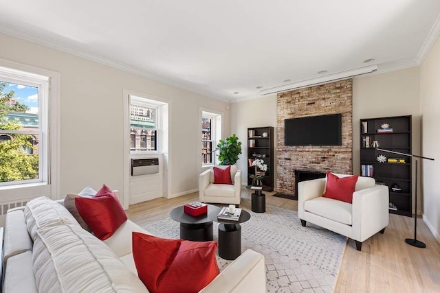 living room with light wood-type flooring, baseboards, ornamental molding, and a fireplace