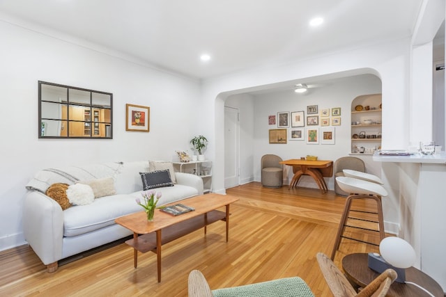 living room featuring built in shelves and light hardwood / wood-style flooring