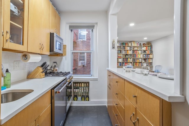 kitchen featuring appliances with stainless steel finishes, dark tile patterned flooring, sink, and decorative backsplash