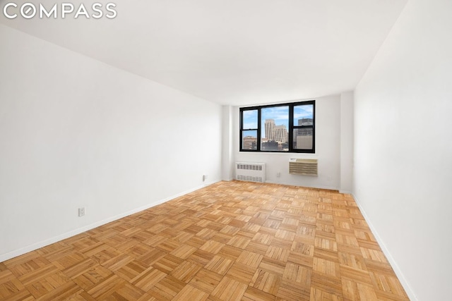 unfurnished room featuring radiator and light parquet floors