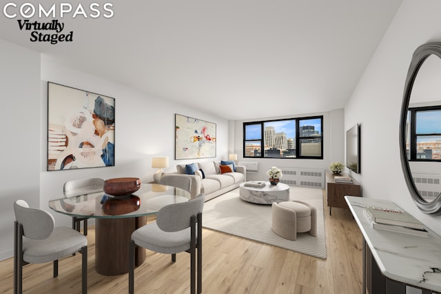 dining space featuring radiator heating unit and light hardwood / wood-style floors