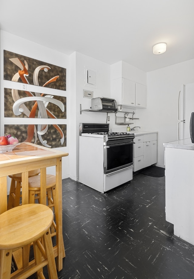 kitchen with white cabinetry, white appliances, and light countertops