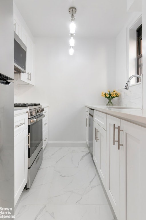 kitchen featuring stainless steel appliances, white cabinets, and sink