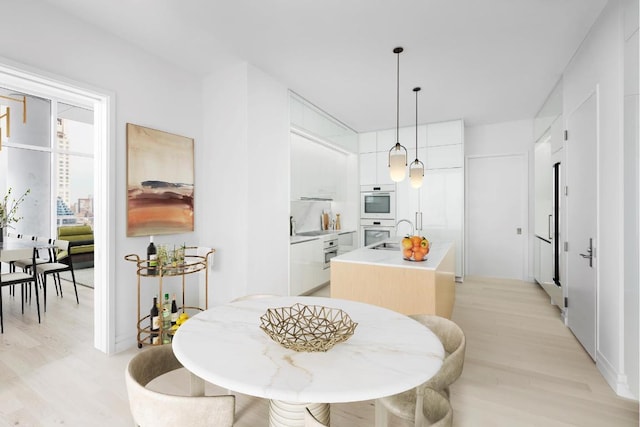 dining area featuring sink and light hardwood / wood-style flooring