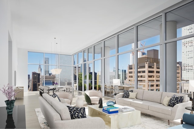 living room with a city view, wood finished floors, floor to ceiling windows, and a healthy amount of sunlight