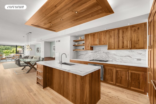 kitchen with visible vents, a sink, decorative backsplash, brown cabinetry, and open shelves