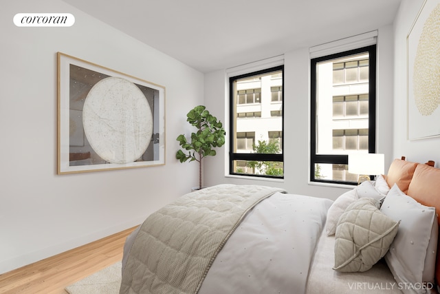 bedroom with wood finished floors, visible vents, and baseboards