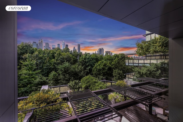 balcony at dusk featuring a view of city