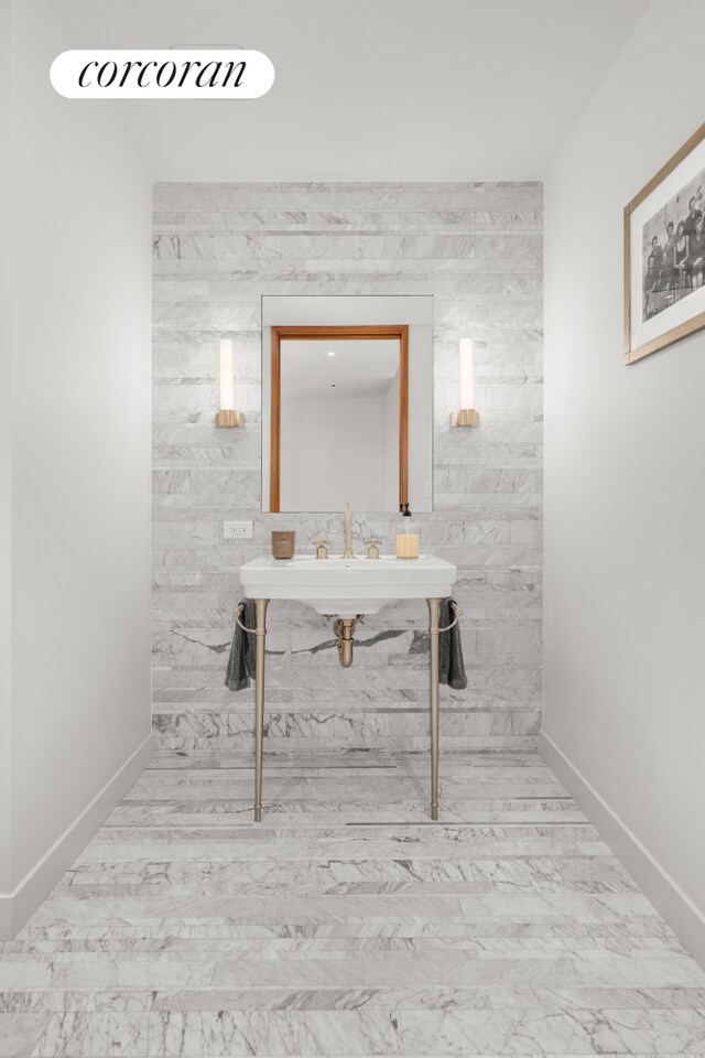 bathroom with marble finish floor and baseboards