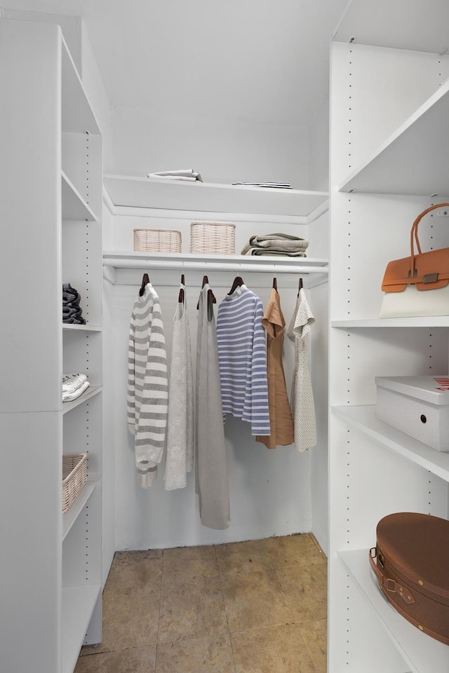 walk in closet with light tile patterned floors