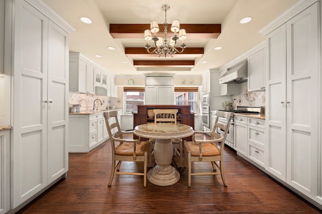 dining room with a chandelier, recessed lighting, beam ceiling, and dark wood finished floors