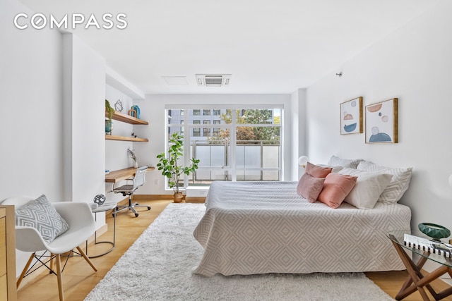 bedroom with visible vents and wood finished floors