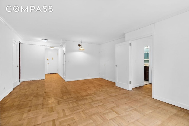 empty room with ornamental molding and baseboards