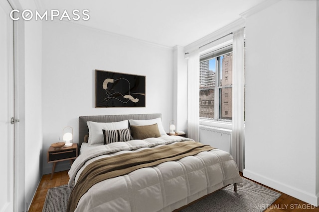 bedroom with ornamental molding, wood finished floors, and baseboards