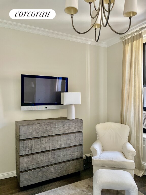 sitting room featuring crown molding, hardwood / wood-style floors, and a chandelier