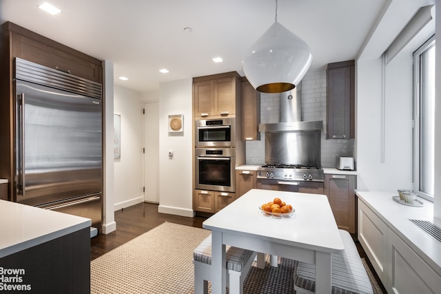 kitchen featuring recessed lighting, light countertops, appliances with stainless steel finishes, dark wood-style floors, and tasteful backsplash