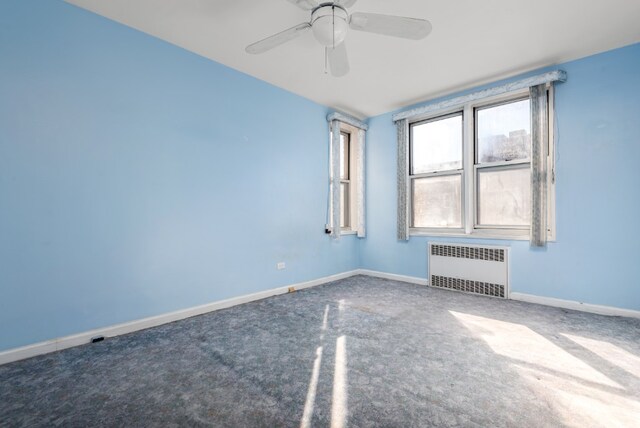 spare room featuring radiator heating unit, a ceiling fan, and baseboards